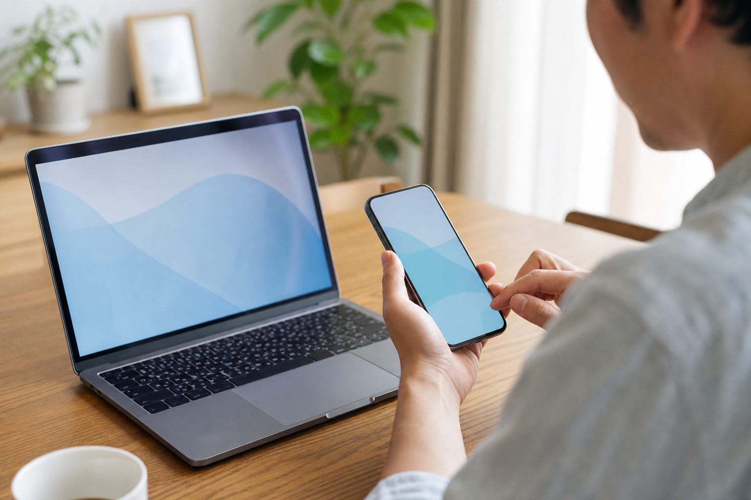 自宅でパソコンとスマートフォンを使う様子